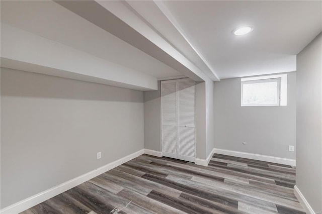 below grade area featuring baseboards and dark wood-style flooring