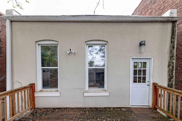 property entrance featuring a deck and stucco siding