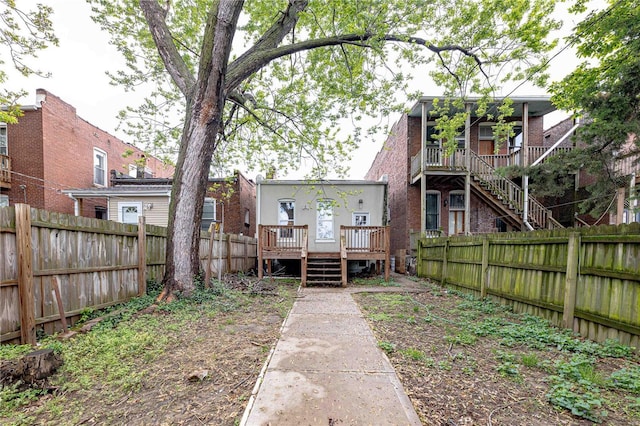 back of property featuring a fenced backyard, stairway, and a deck