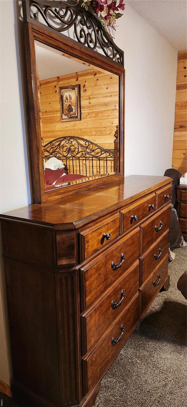 room details with wooden walls, carpet, and a textured ceiling