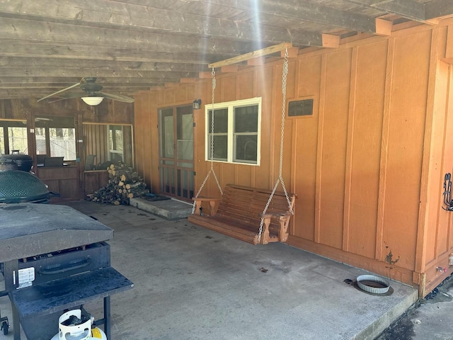 exterior space featuring a patio area, board and batten siding, and ceiling fan