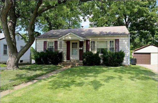 bungalow-style home featuring a garage, a front yard, and an outdoor structure