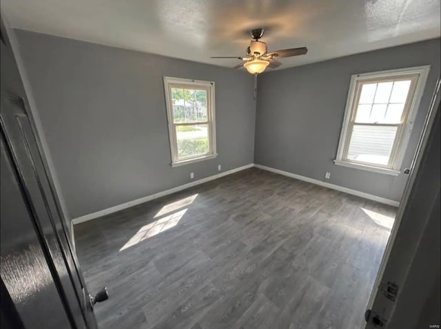 unfurnished bedroom featuring ceiling fan, baseboards, and dark wood-style floors