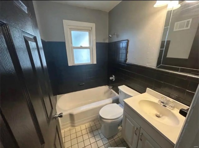 bathroom featuring visible vents, toilet, tile walls, bathtub / shower combination, and tile patterned floors