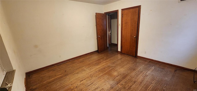 unfurnished room featuring baseboards and wood finished floors