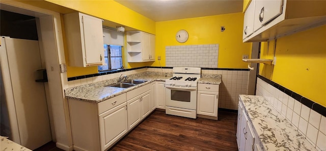 kitchen with white appliances, white cabinetry, open shelves, tile walls, and a sink
