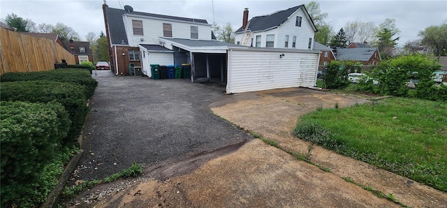 rear view of property featuring brick siding and fence