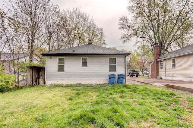 rear view of property with a yard and a chimney