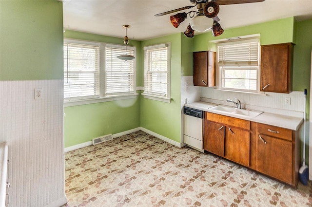 kitchen with visible vents, white dishwasher, ceiling fan, light countertops, and a sink
