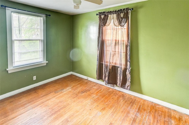 unfurnished room featuring baseboards, a ceiling fan, and wood finished floors