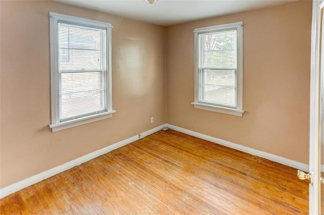 empty room with baseboards and wood finished floors