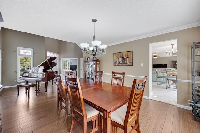 dining room with baseboards, a notable chandelier, and wood finished floors