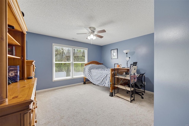carpeted bedroom featuring baseboards, a ceiling fan, and a textured ceiling