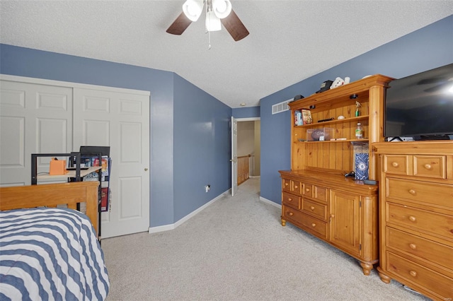 bedroom featuring a ceiling fan, a textured ceiling, visible vents, baseboards, and light carpet