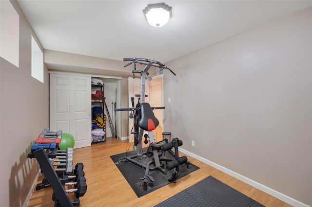 exercise area with baseboards and wood finished floors