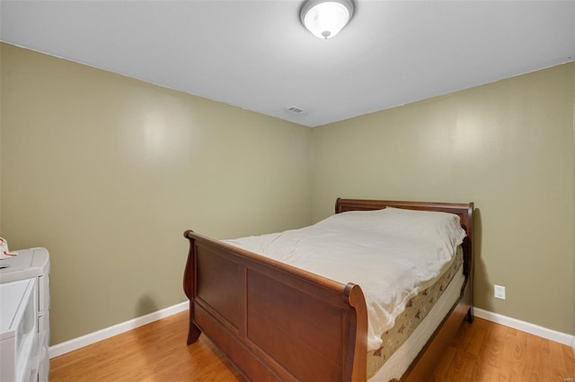 bedroom featuring baseboards, light wood-style flooring, and visible vents