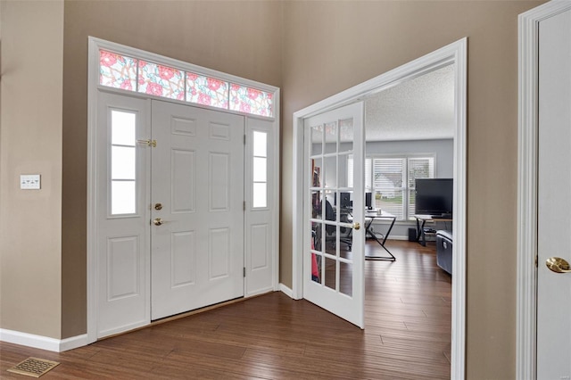 entrance foyer featuring dark wood-style flooring, baseboards, and visible vents
