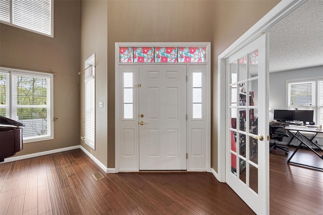 foyer featuring baseboards, dark wood-style floors, french doors, and visible vents