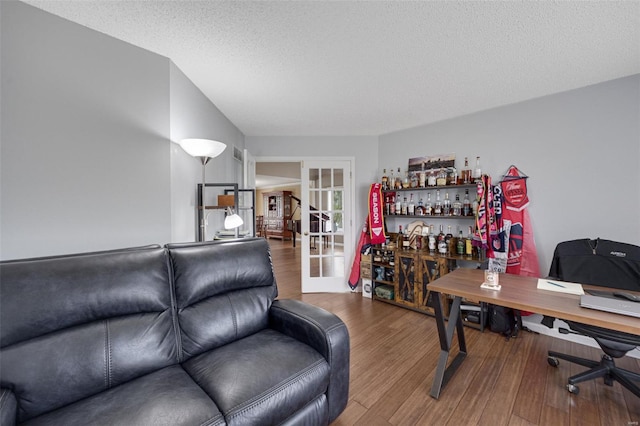 office area with a textured ceiling, french doors, a dry bar, and wood finished floors