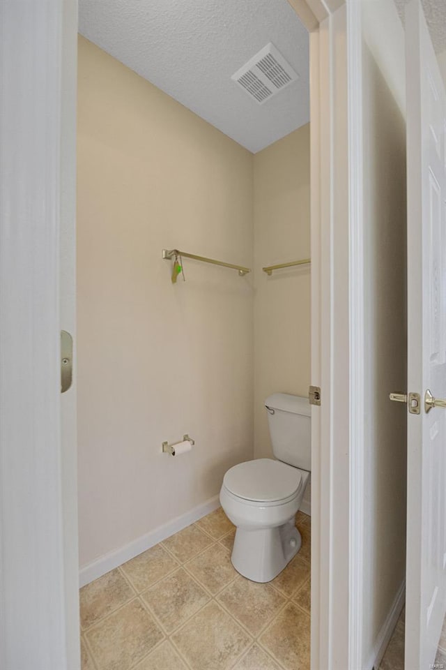 bathroom featuring baseboards, tile patterned flooring, toilet, and visible vents