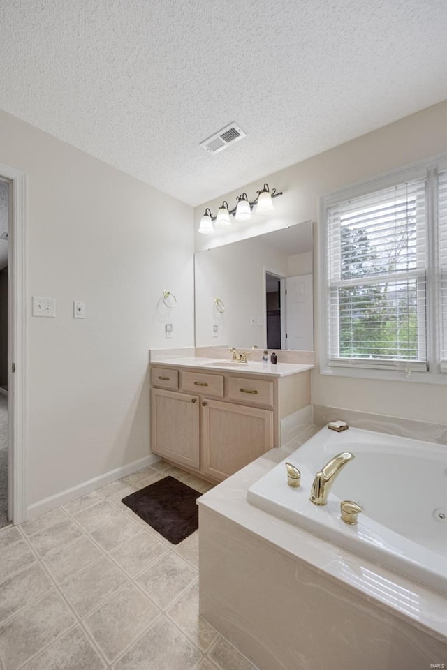 bathroom featuring visible vents, a garden tub, vanity, a textured ceiling, and tile patterned floors