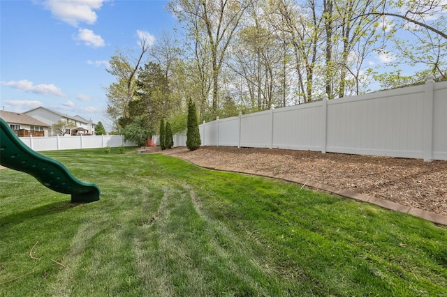 view of yard featuring a fenced backyard and a playground