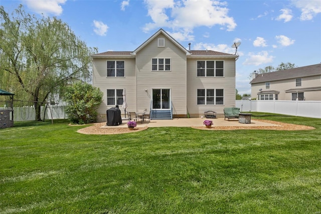 rear view of property featuring a fenced backyard, a yard, a fire pit, and a patio area
