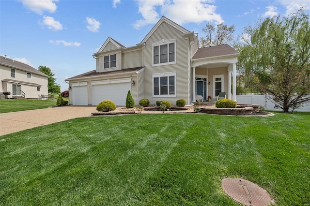 traditional-style house with fence, roof with shingles, an attached garage, a front yard, and concrete driveway