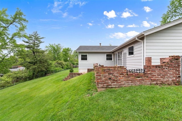 rear view of house with a lawn and fence
