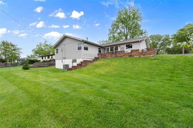 rear view of house featuring fence and a yard