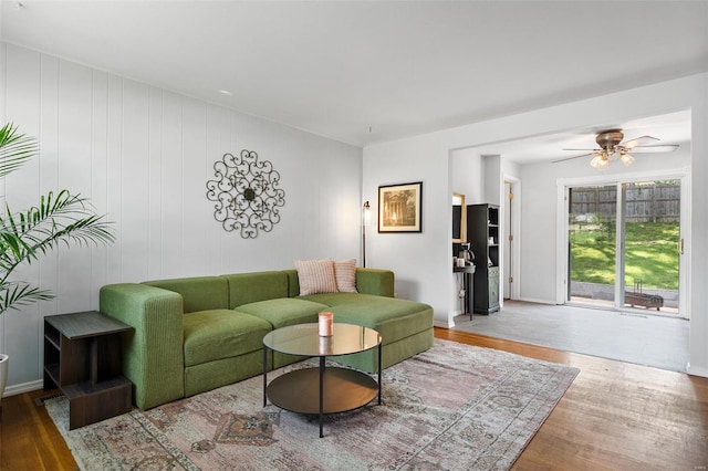 living area with a ceiling fan and wood finished floors