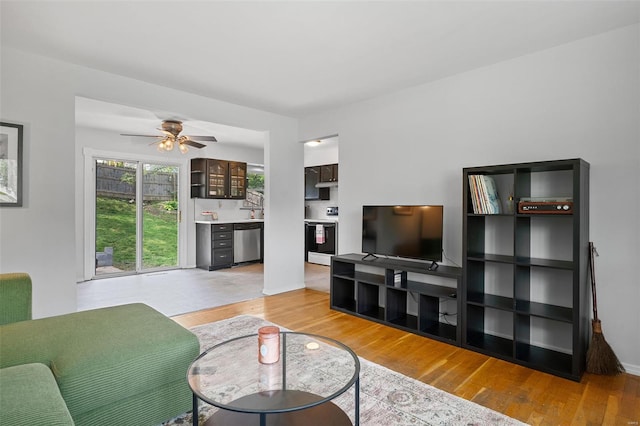 living area with light wood-type flooring and a ceiling fan