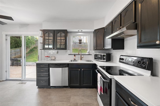 kitchen featuring ceiling fan, a sink, light countertops, stainless steel appliances, and under cabinet range hood