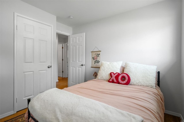 bedroom featuring baseboards and wood finished floors