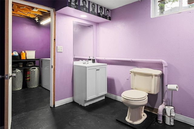 half bath featuring baseboards, vanity, and toilet