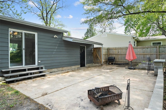 view of patio featuring entry steps, fence, and a fire pit