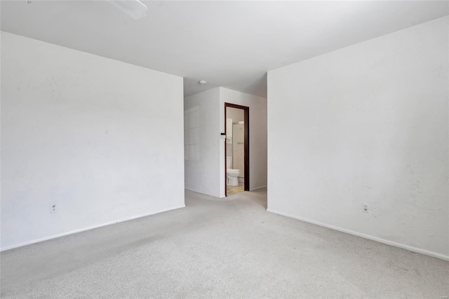 spare room with baseboards and carpet flooring