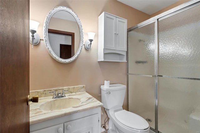 full bathroom with toilet, a stall shower, and vanity