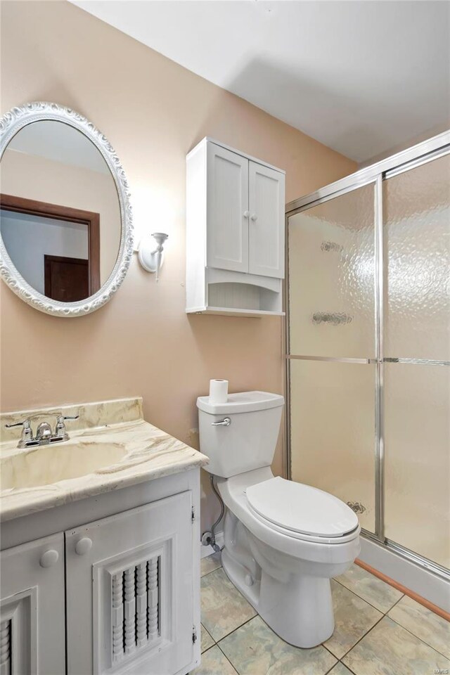 full bath featuring tile patterned floors, vanity, a stall shower, and toilet