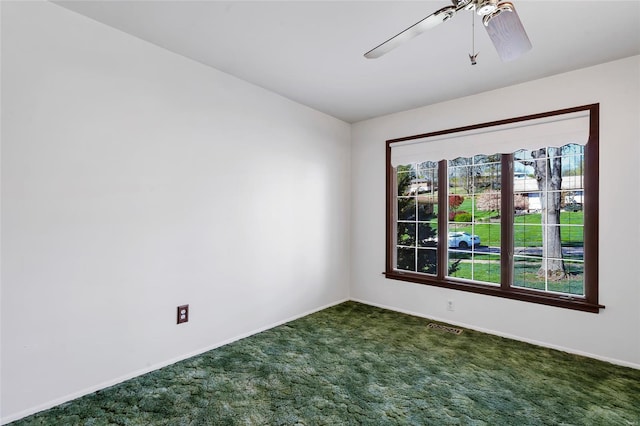 unfurnished room with dark carpet, ceiling fan, baseboards, and visible vents