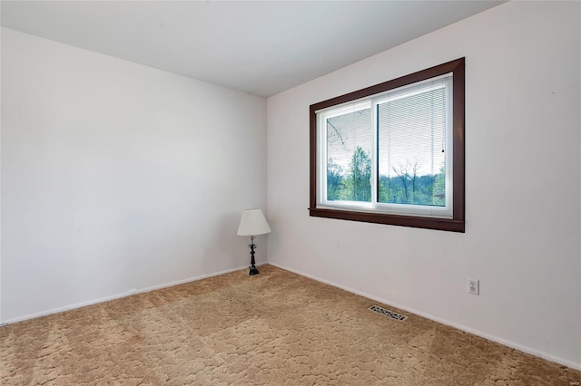 carpeted empty room featuring visible vents and baseboards
