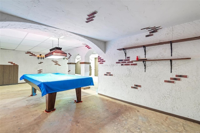 recreation room with a paneled ceiling, concrete floors, and billiards