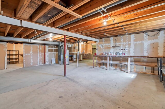 unfinished basement with gas water heater and a workshop area