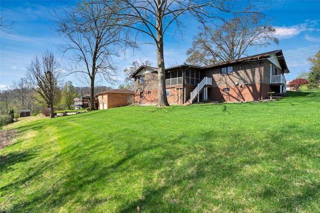 exterior space featuring stairway, a sunroom, and a lawn