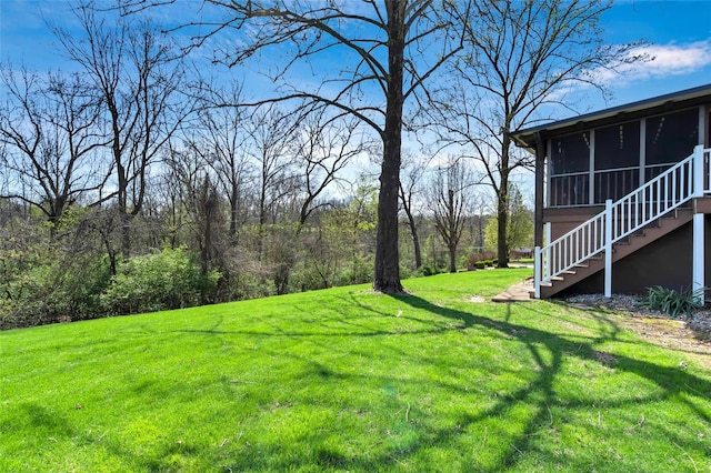 view of yard with a sunroom and stairs