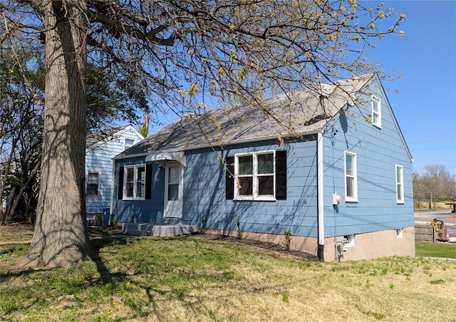 bungalow featuring a front yard and a shingled roof