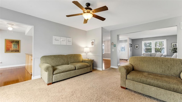 living room with baseboards and a ceiling fan