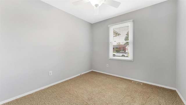 unfurnished room with baseboards, a ceiling fan, and carpet