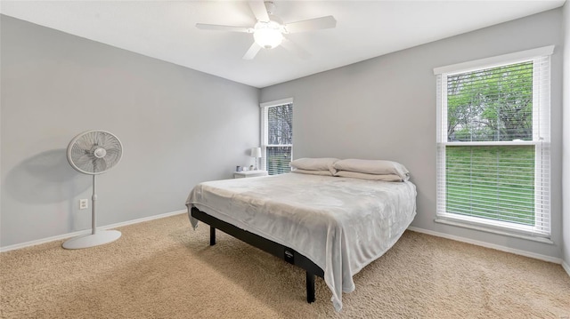 carpeted bedroom featuring baseboards and a ceiling fan