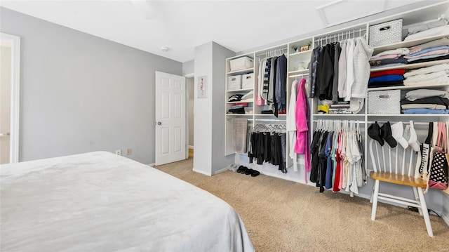 carpeted bedroom with a closet, attic access, and baseboards